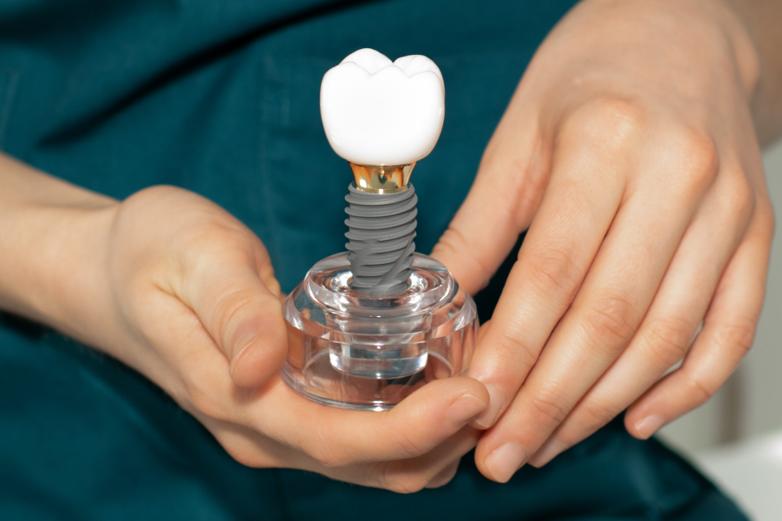 Medic stomatolog montând implant dentar pacientului într-un cabinet modern